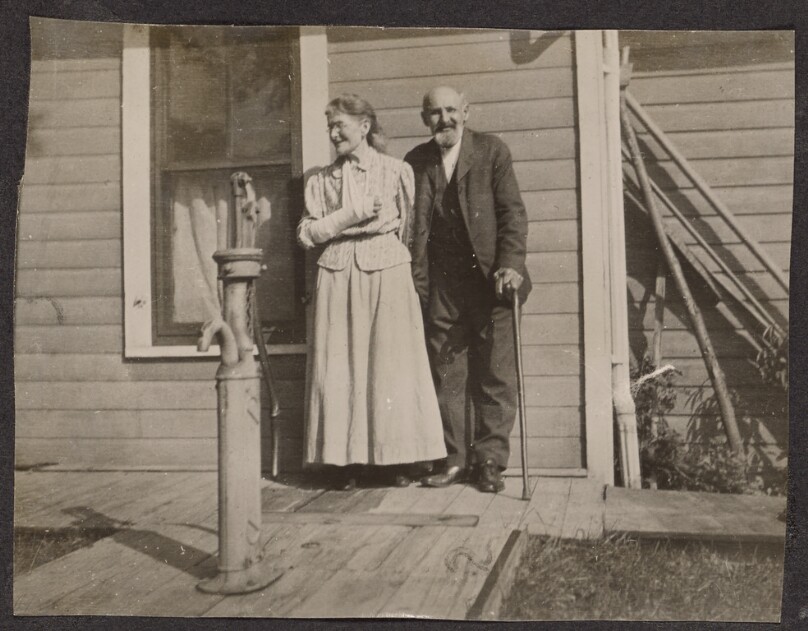 [Elderly man and woman pose for the camera]