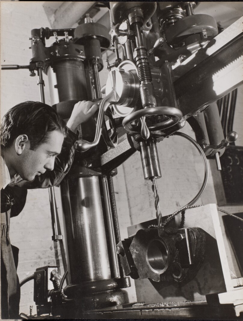 [Man works with machinery with a drill bit attached]