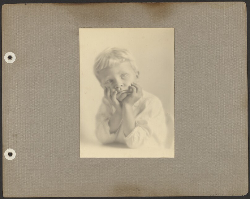 [Brett Weston in white tunic, leaning with chin in hands]