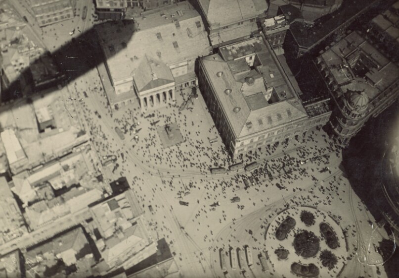 [Cityscape with blimp shadow]