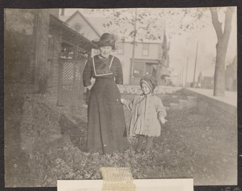 [Woman and child in a front yard]