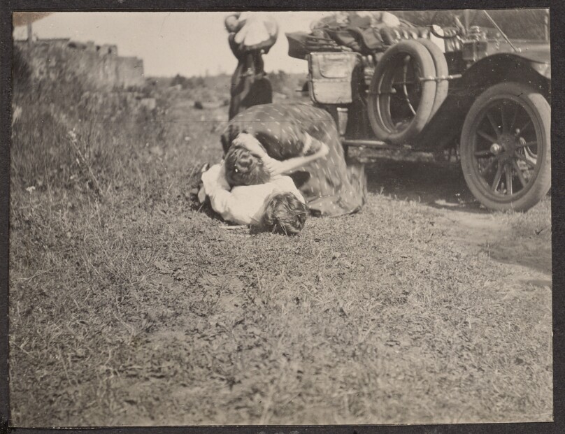 [Women playing around next to a car]