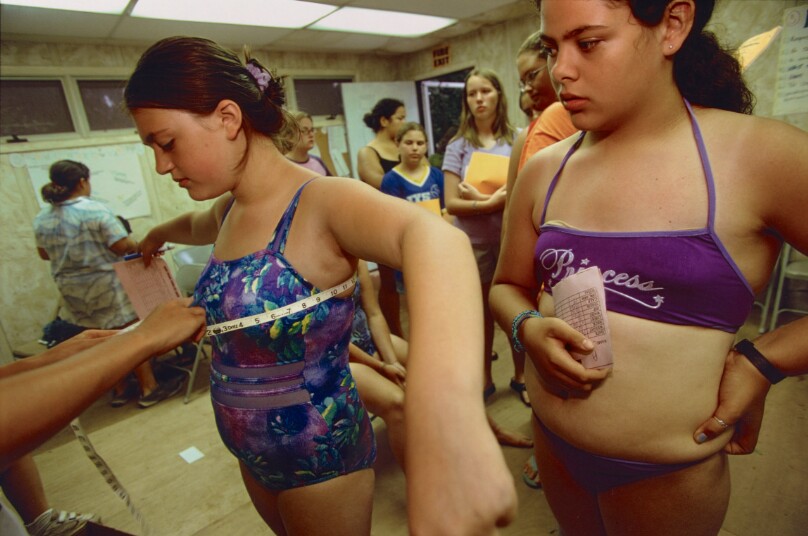 Danielle, 13, gets measured as Michelle, 13, waits for the final weigh-in on the last day of weight-loss camp, Catskills, New York