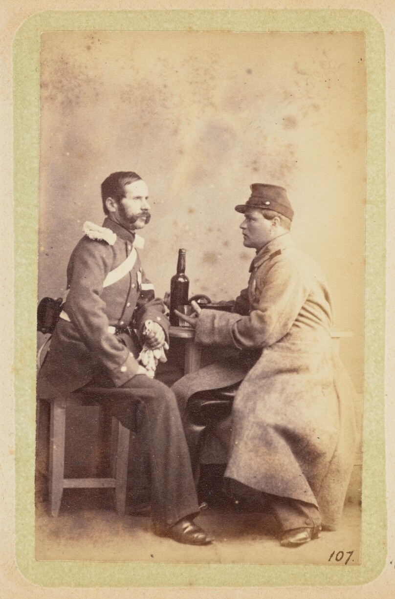 [Two men seated at a table]