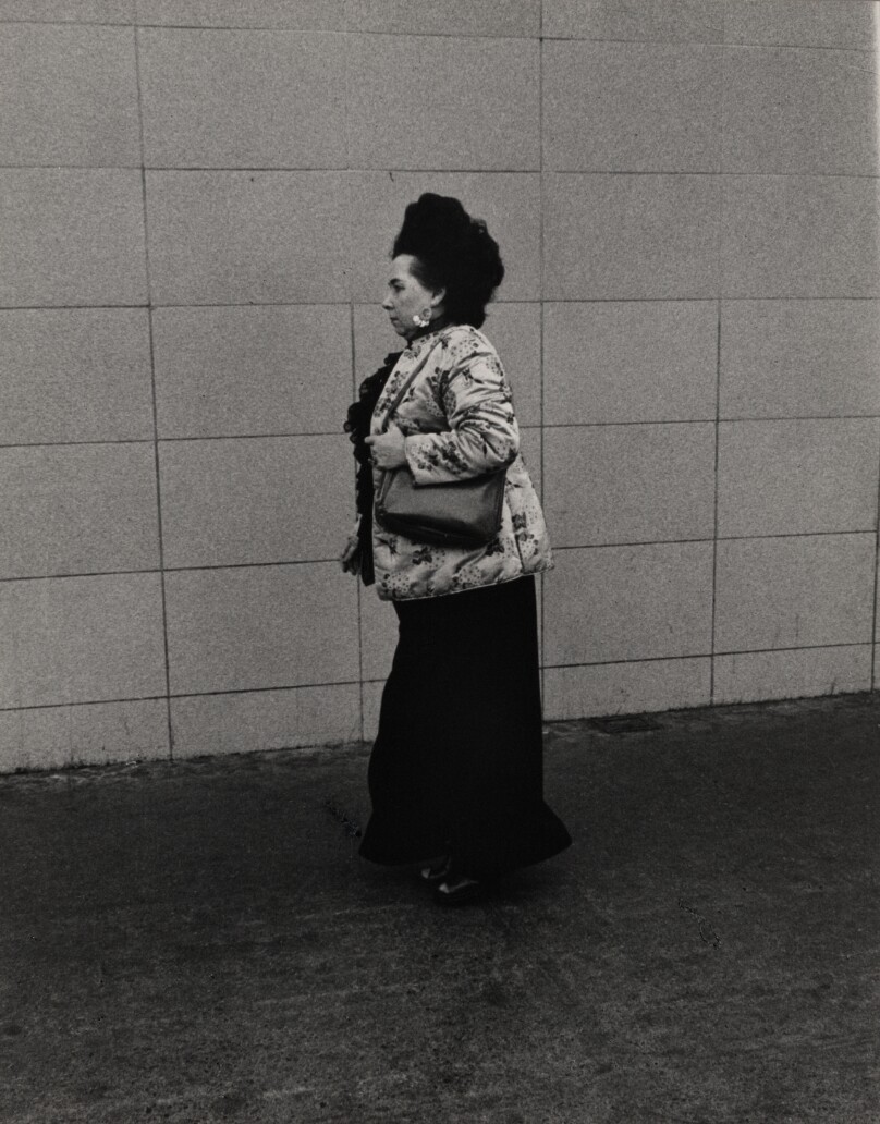 [Woman walking past a wall]