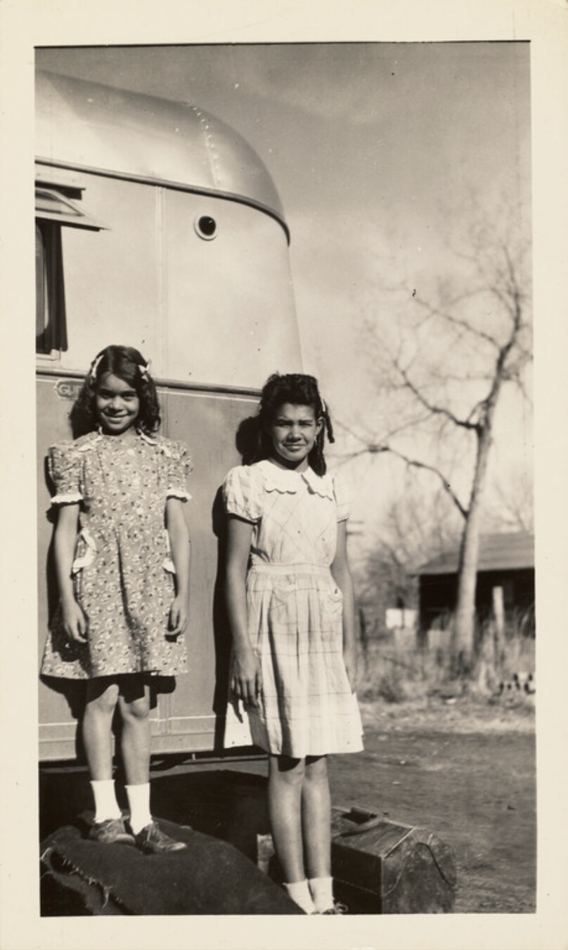 [Two young girls next to trailer]