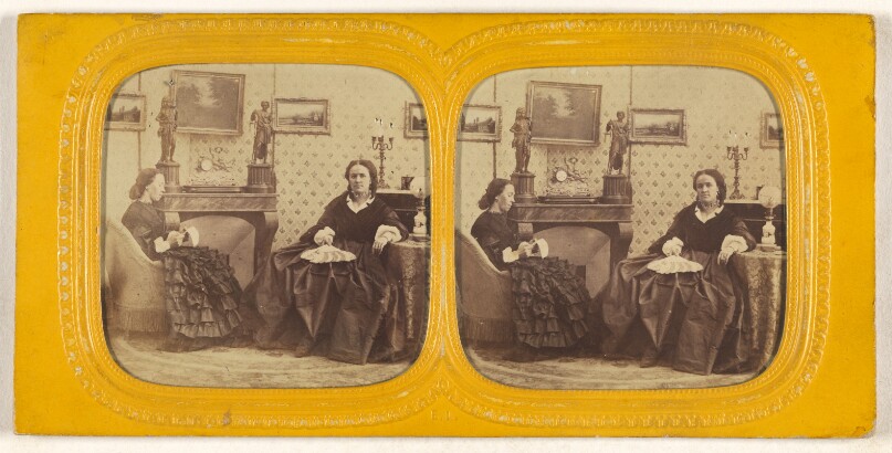 [Two women seated in a parlor, one is sewing, the other with a hand fan in her lap]