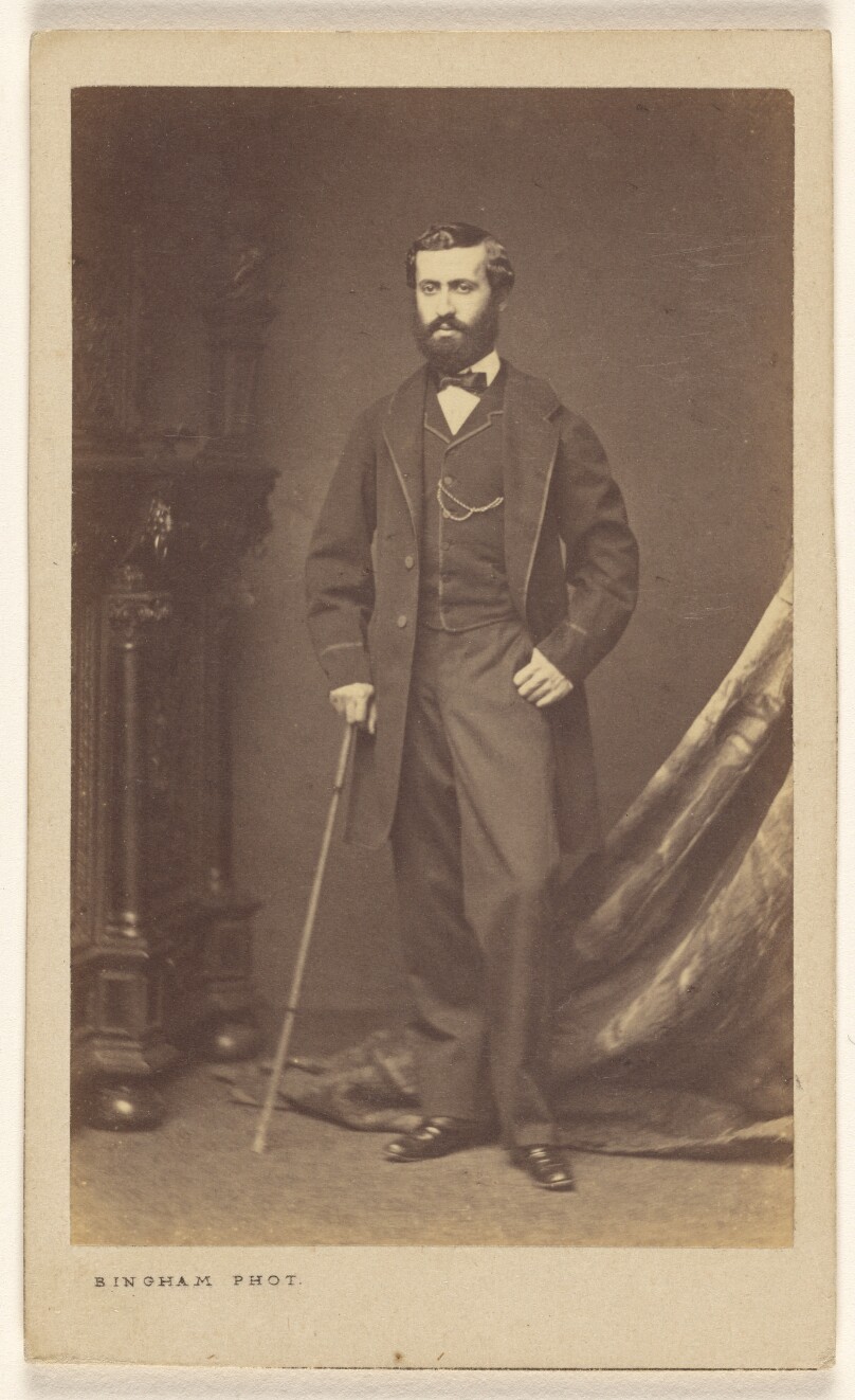 [Unidentified bearded man with walking stick, standing]
