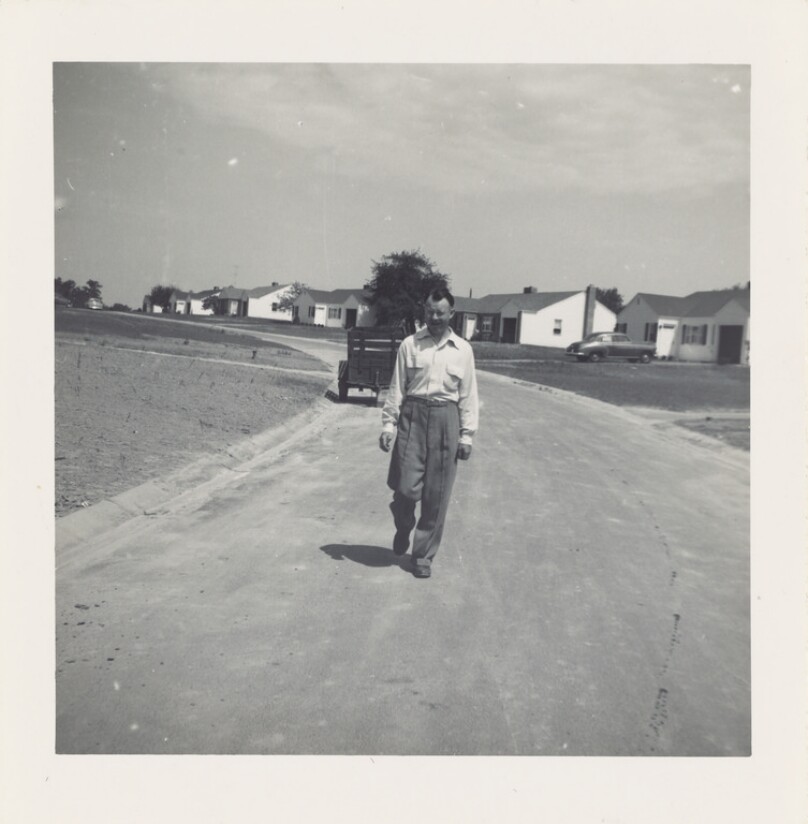 [Man walking along dirt road]