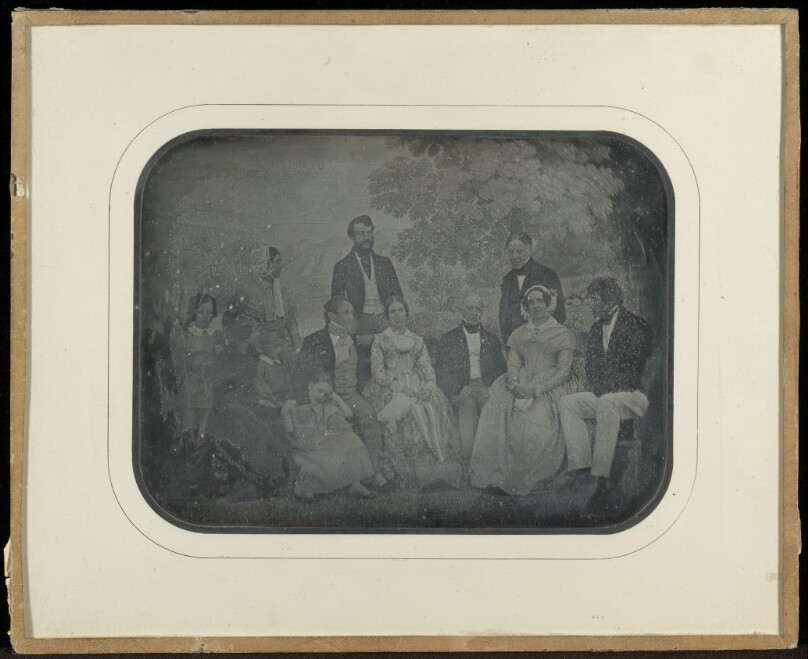 Group portrait of twelve member of the Circle of Eynard-Lullin in front of tapestry