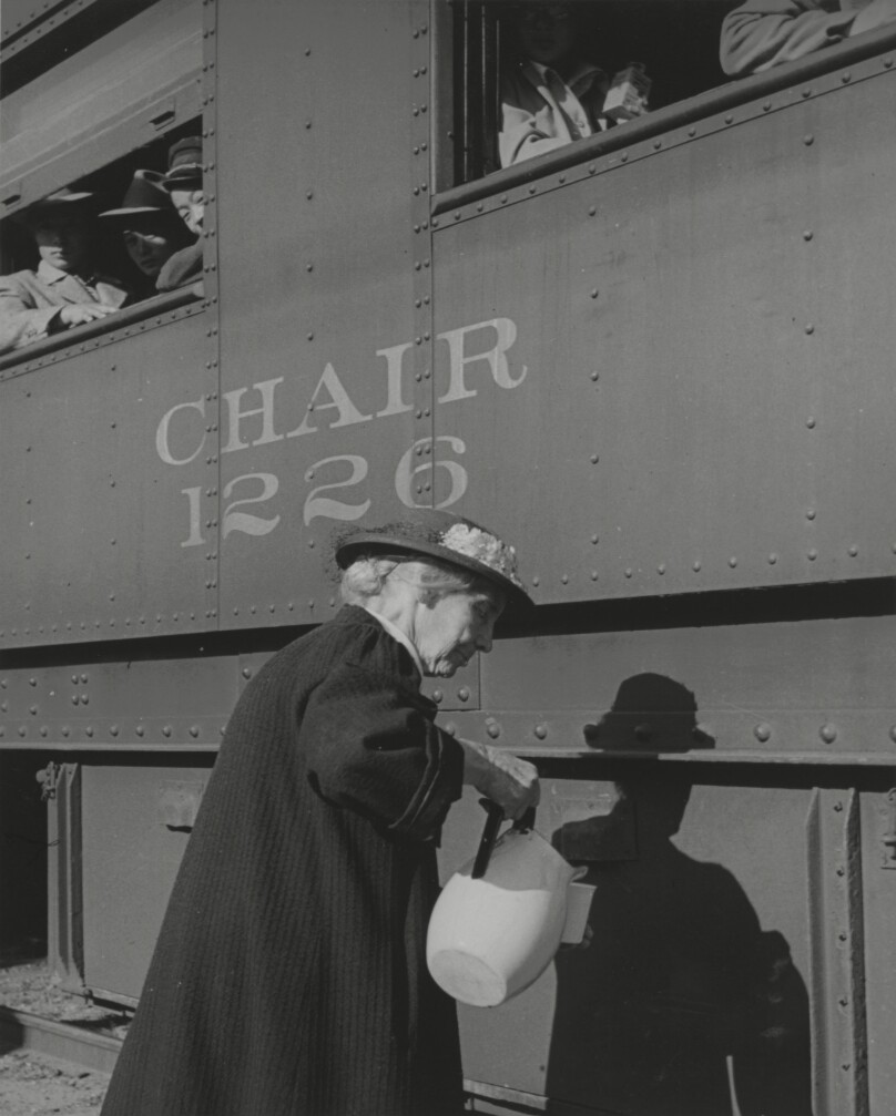 [Volunteer pouring juice for train passengers]