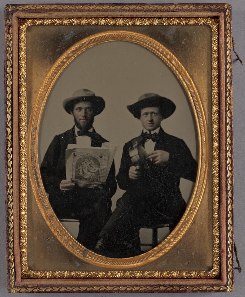 [Portrait of two seated men wearing bow ties and hats]