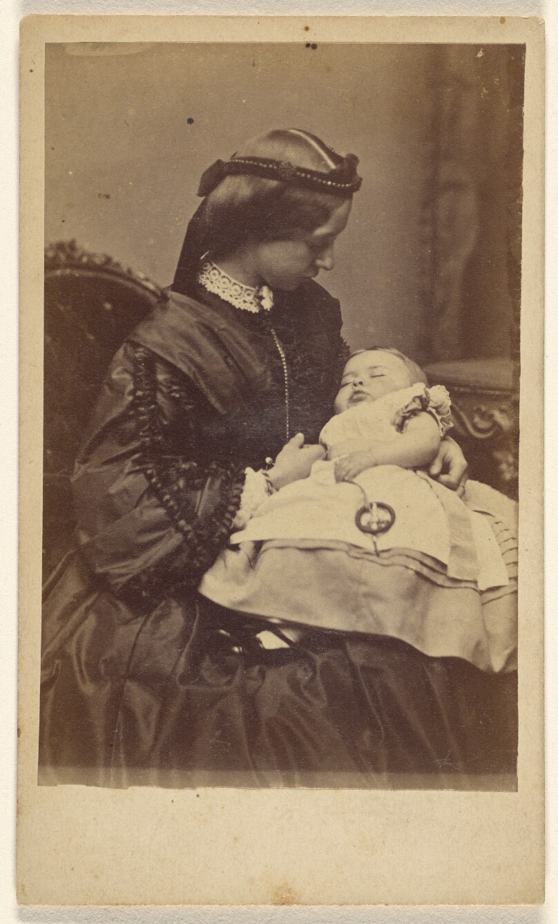 [Unidentified woman holding sleeping child, seated]