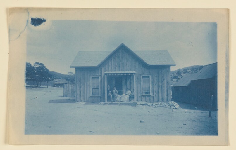 [Four figures and cabin]
