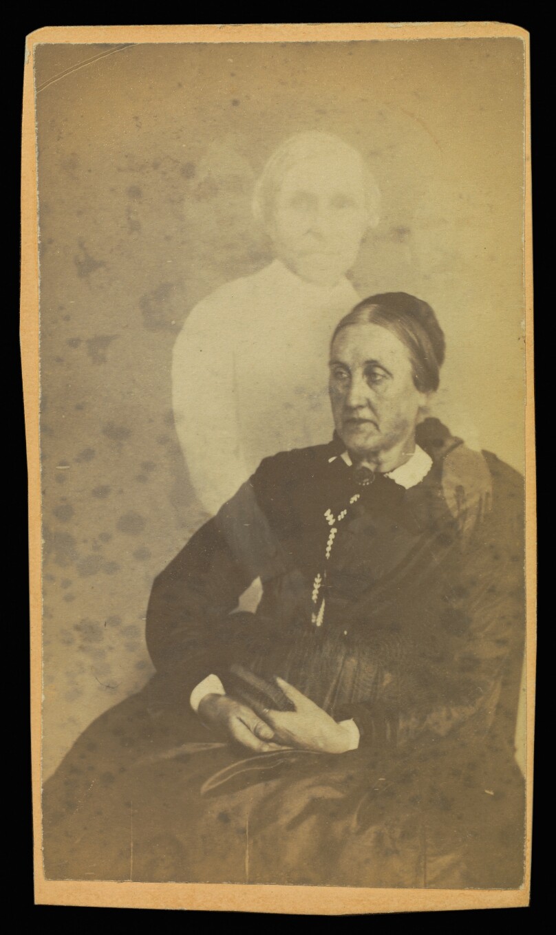 [Unidentified elderly woman seated, three "spirits" in the background]
