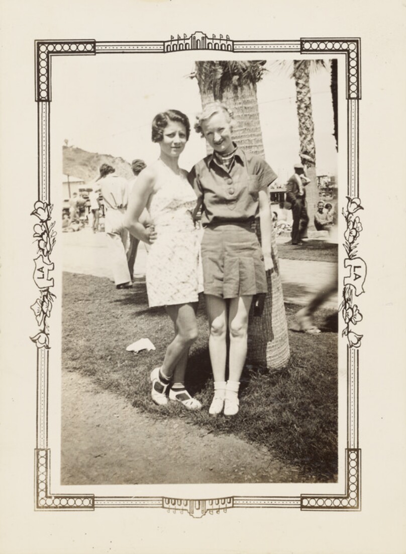 [Two women in front of palm tree]