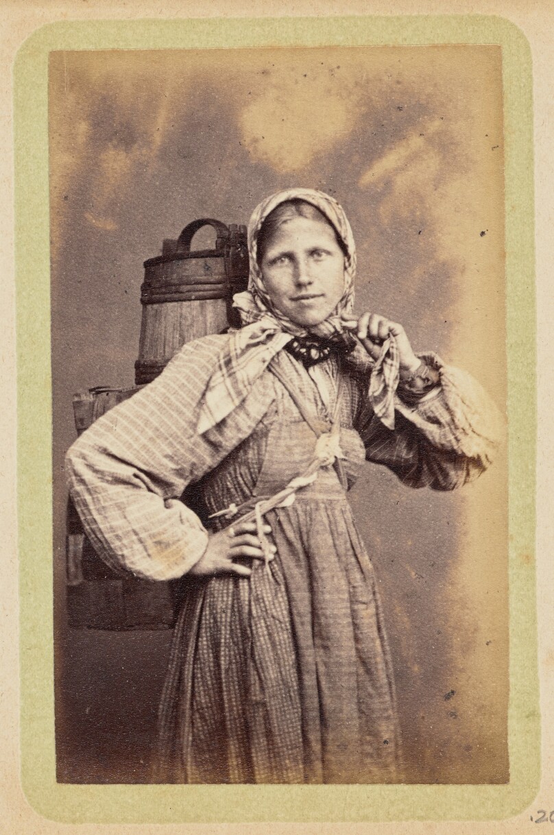 [Woman with buckets strapped to her back]