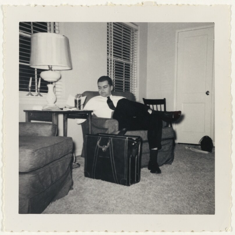 [Seated man with suitcase]