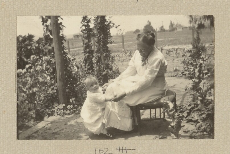 [Woman sitting, young child standing]