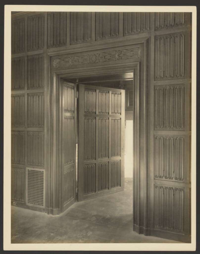 [Wood paneled wall with door]