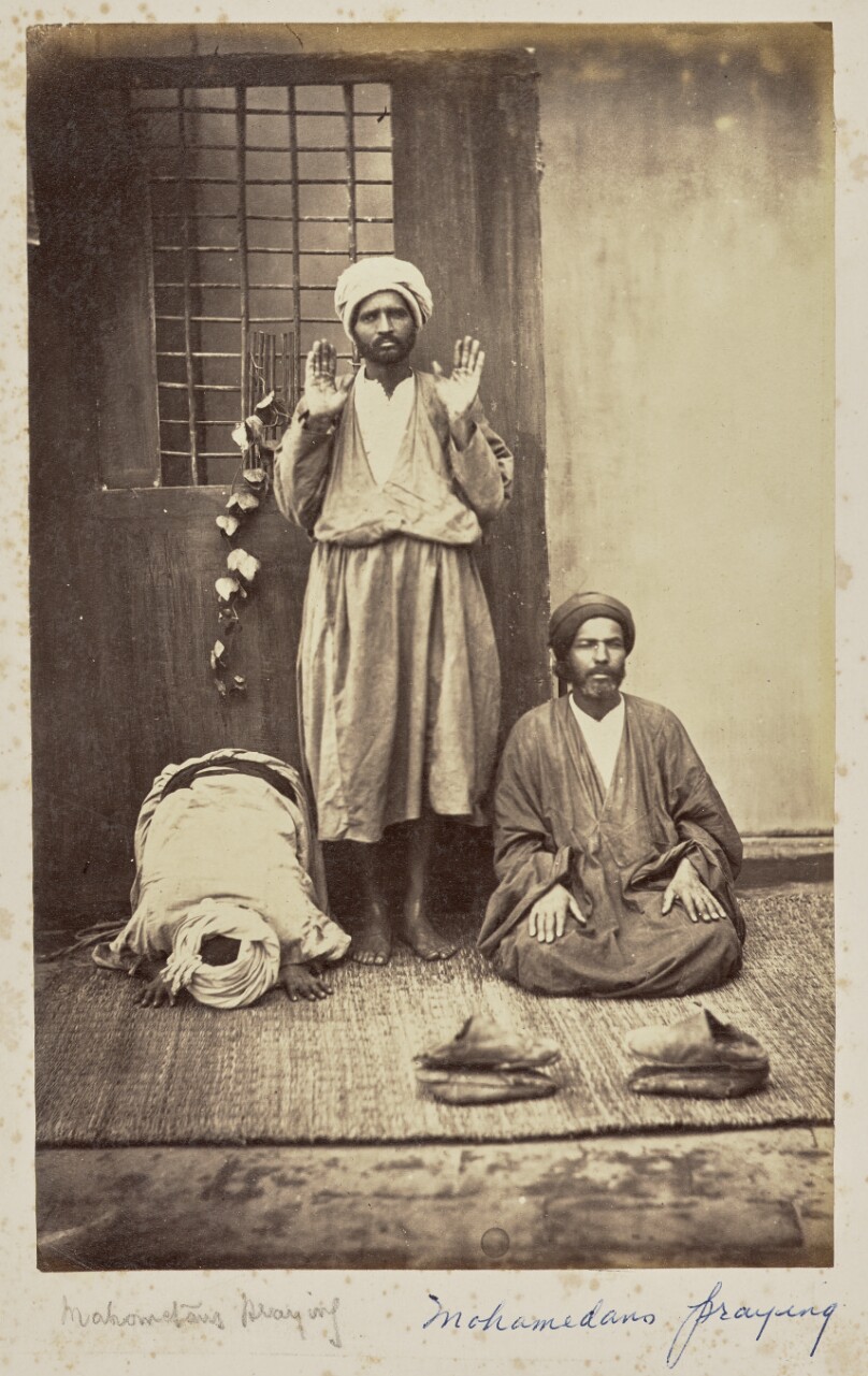 [Three men demonstrating the Muslim prayer]