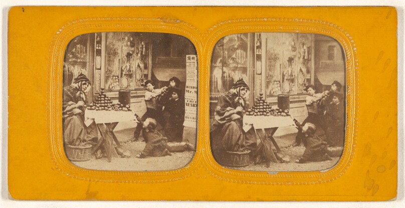 [Street scene: woman selling apples, group of children nearby, one trying to steal an apple off the table]