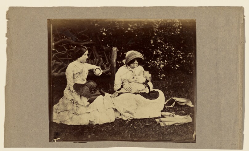 [Child asleep with two woman seated on grass]