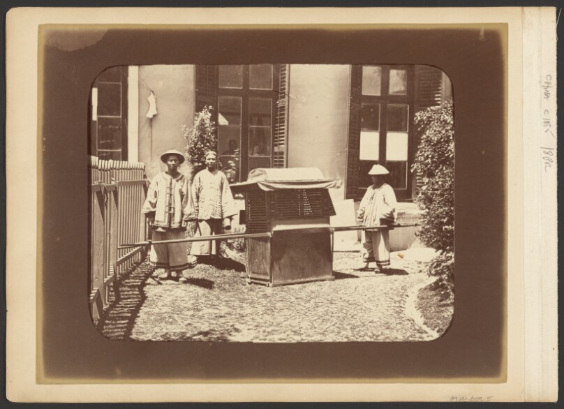 [Men standing beside litter]