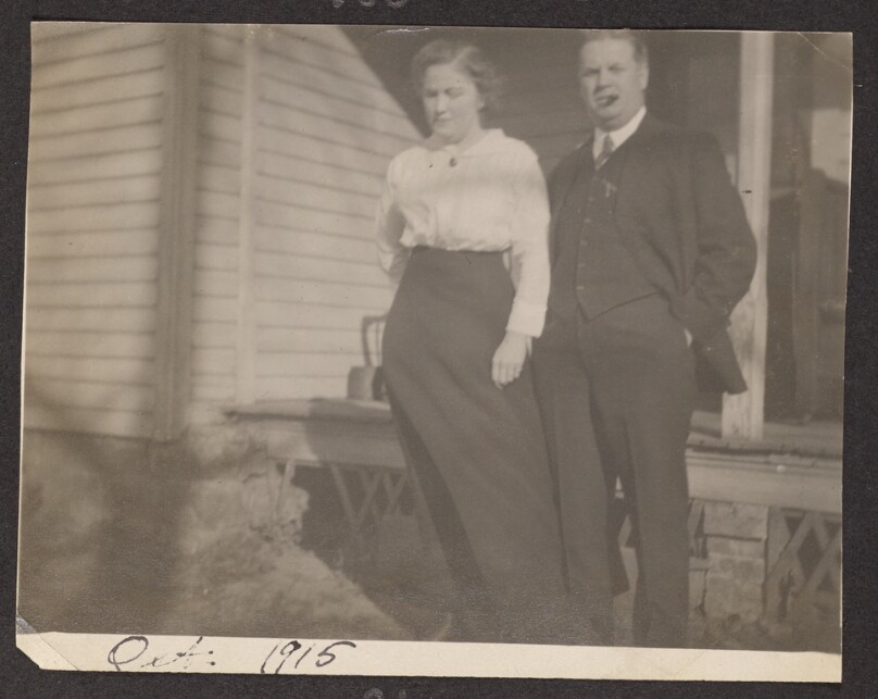 [Woman and man pose in front of a porch]