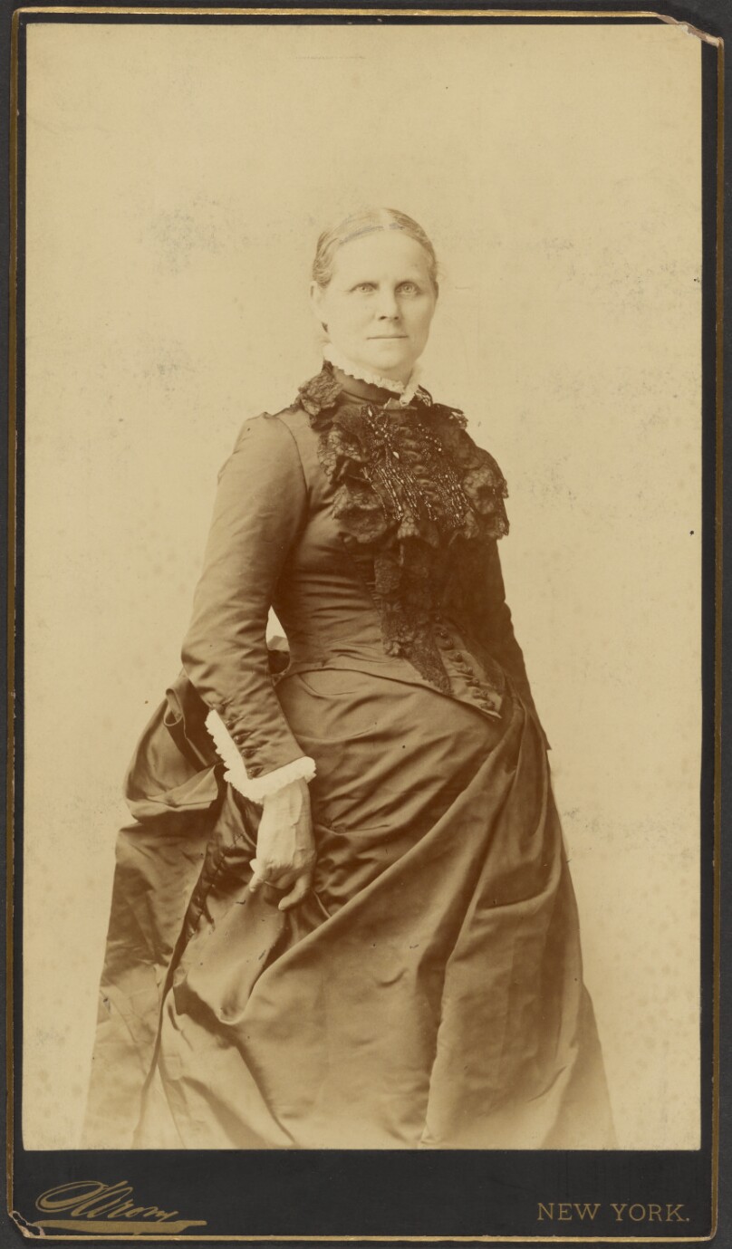 [Unidentified woman in long dress standing]