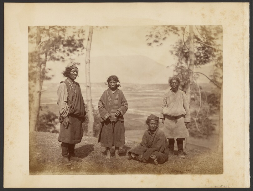 [Four Tibetan figures on hillside]
