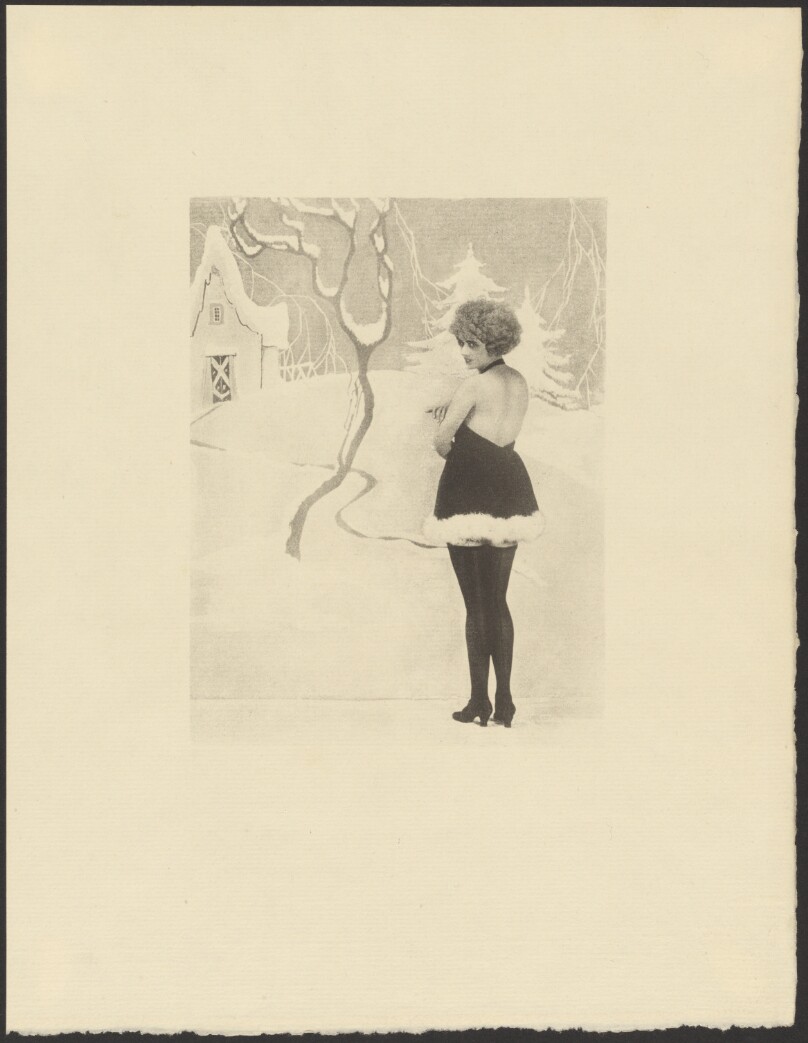 [Female Model Dressed in Santa Claus-like Outfit Posed in Front of a Painted Backdrop of a Snowy Winter Scene]