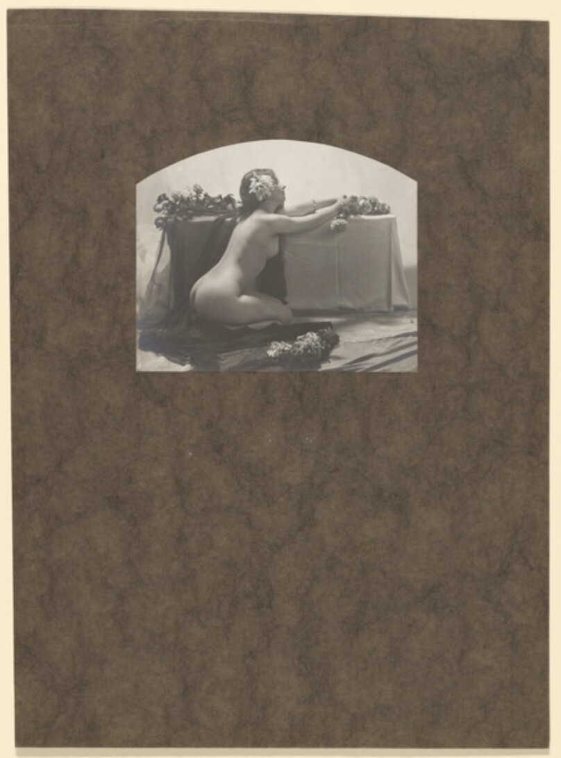 [Female nude kneeling by table]