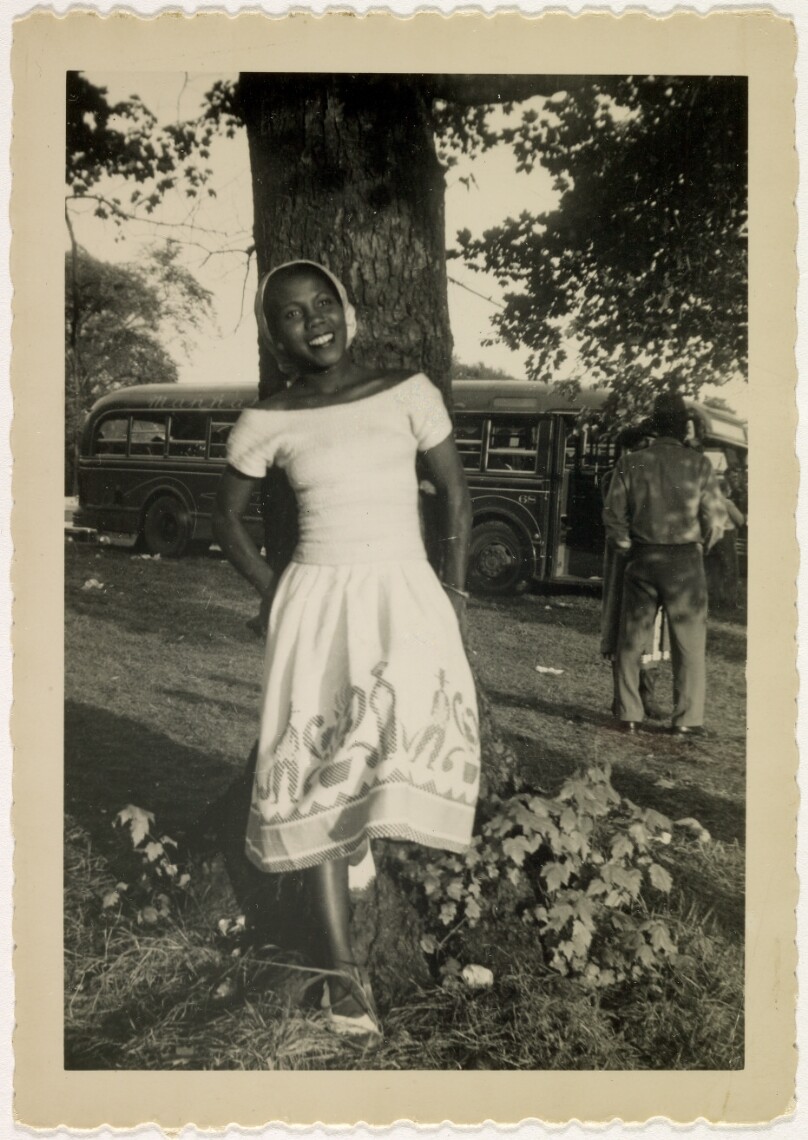[Woman leaning against tree]