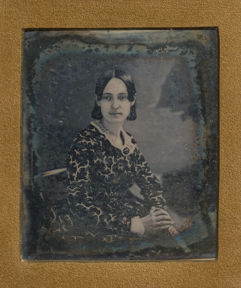 [Portrait of a seated woman in patterned dress]