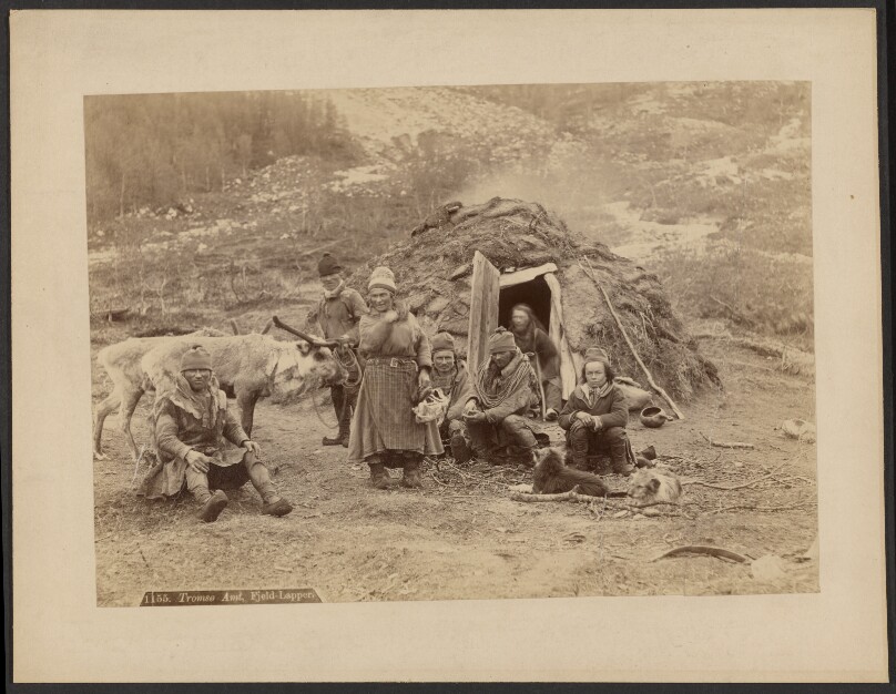 [Sami people outside traditional peat hut]
