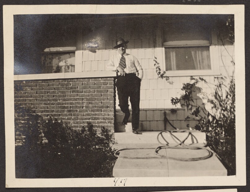 [Man posing outside a house]