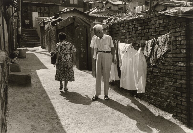 [Elderly Man Watching a Woman Walk Away Up an Alley]