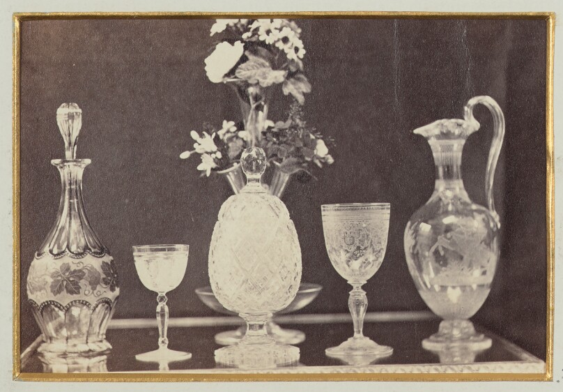 [Ornate water pitcher, two goblets, two decanters with flower arrangement]
