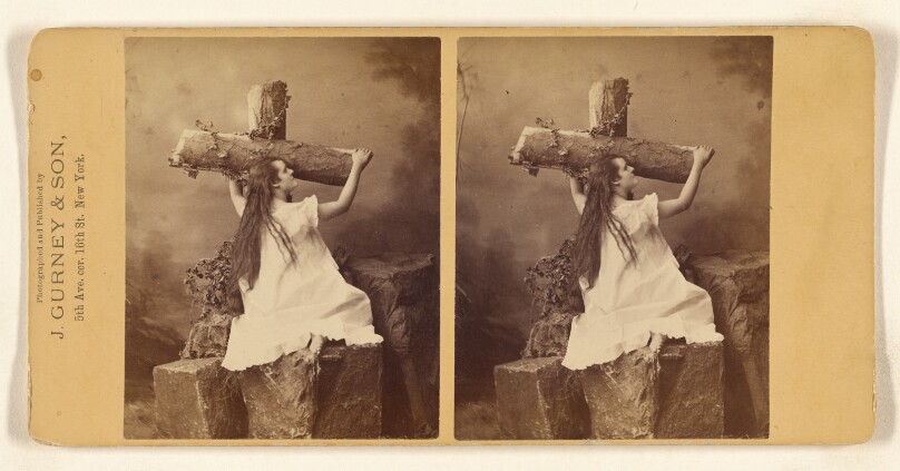 [Woman holding on to a cross made out of logs]