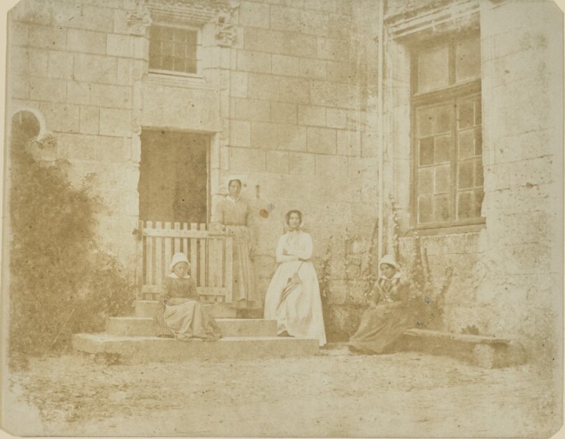 [Four Women outside an Entrance to a Stone Building]