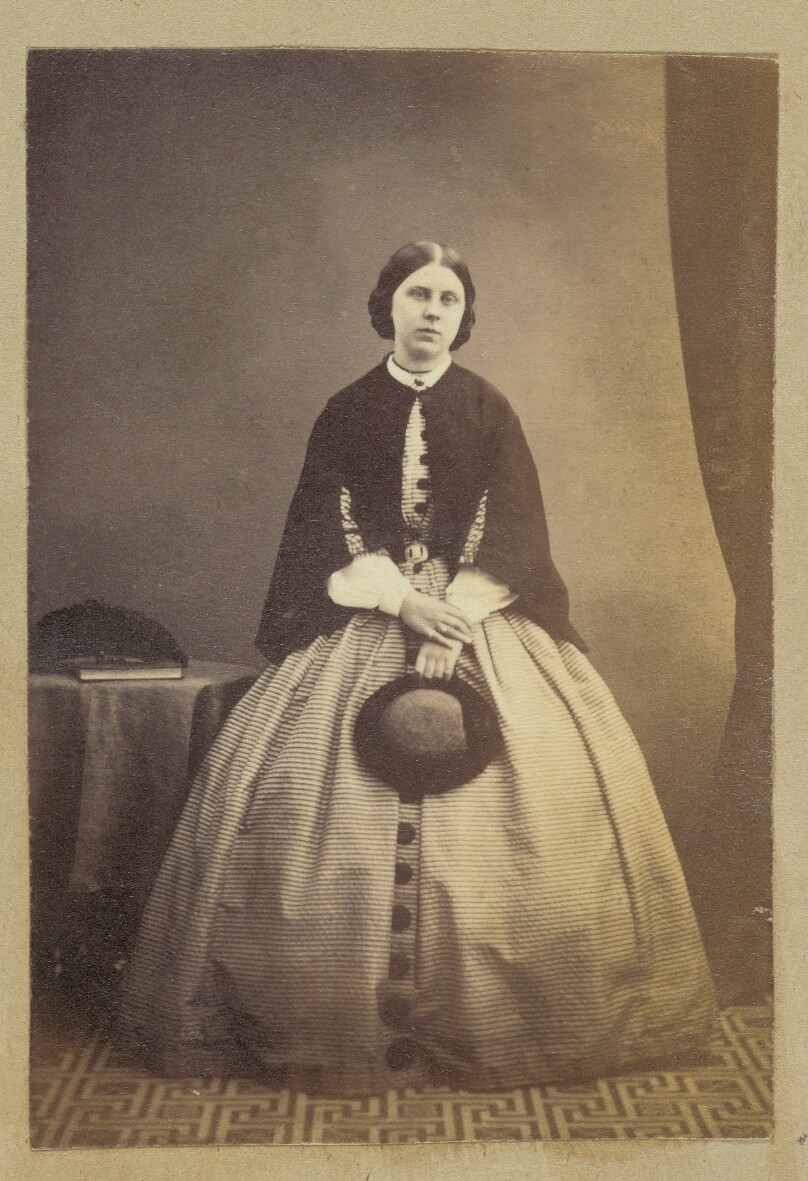 [Portrait of woman holding hat]