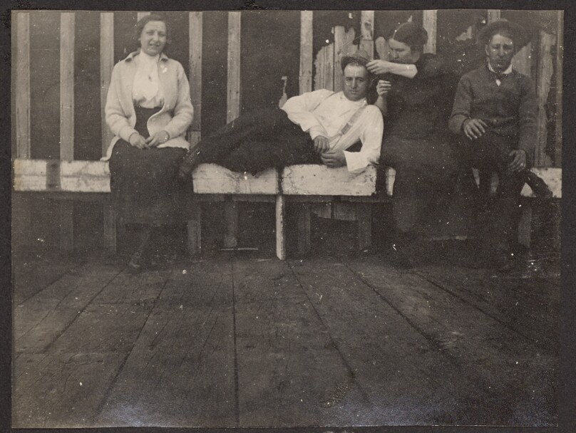 [Group portrait on wooden benches]