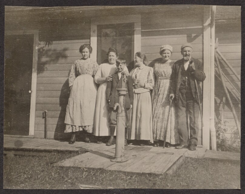 [Group portrait in front of a house]