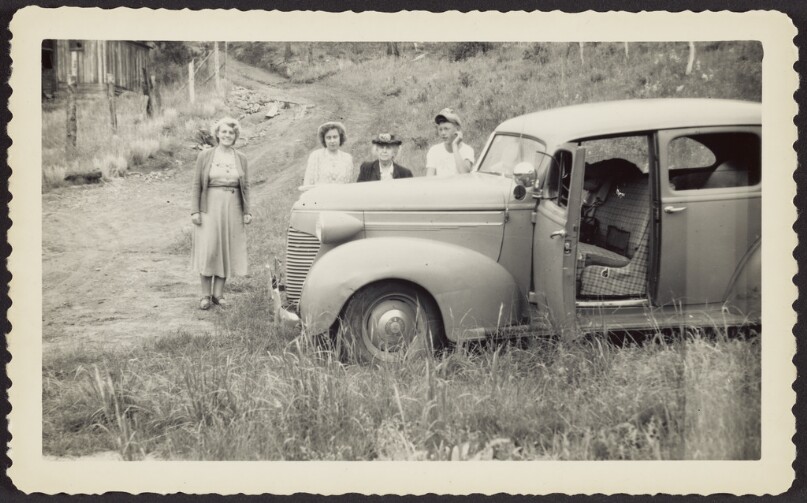 Four people next to car