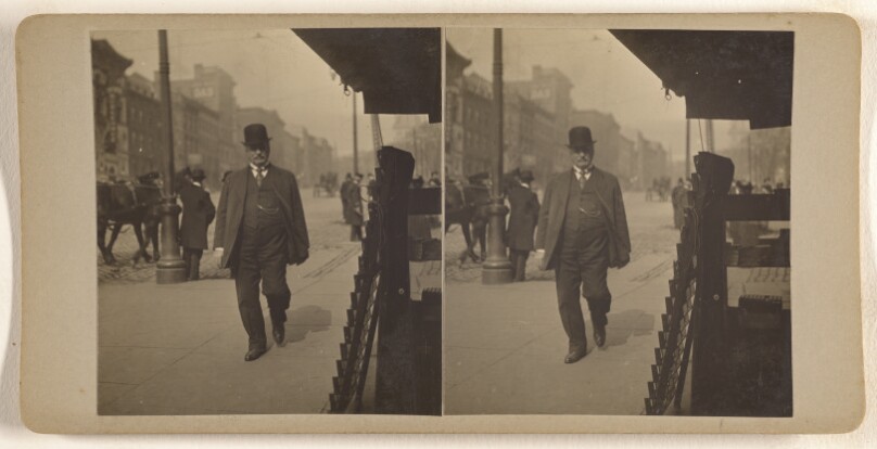 [Man in derby walking down street, Albany, N.Y.]