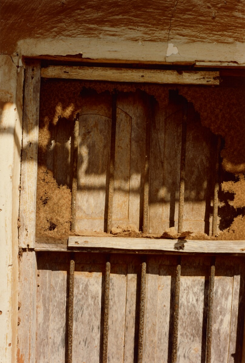 [Boarded-up Window with Bars]
