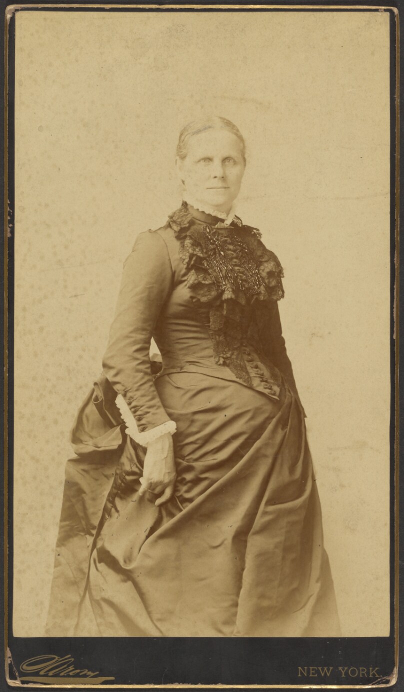 [Unidentified woman in long dress standing]