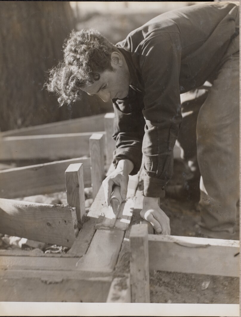[Mason smooths cement while pouring a foundation]