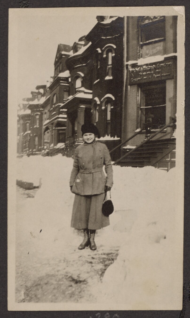 [Woman standing on a snowy sidewalk]